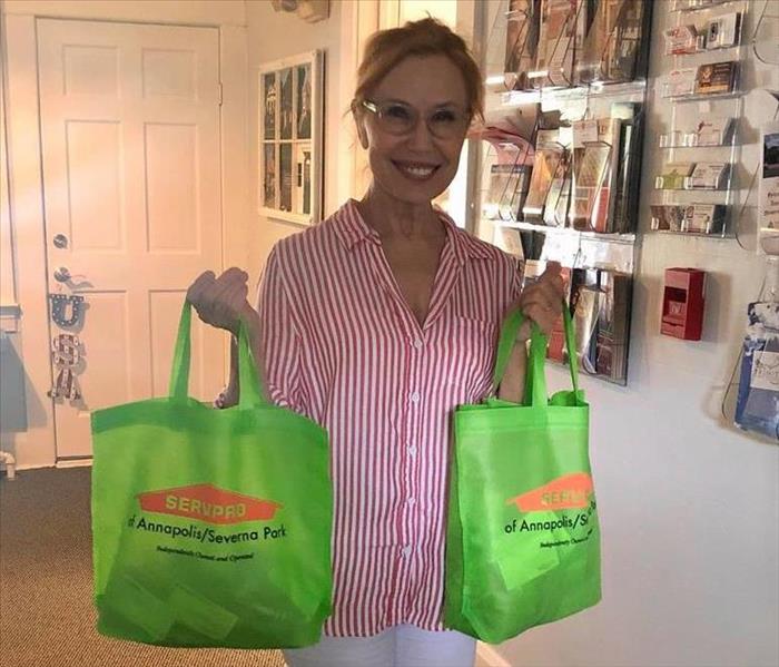 Liz CEO of the Chamber of Commerce holding canvas goodie bags